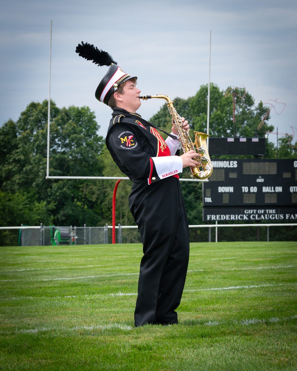 A DLS Innovations band portrait of a student musician holding a saxophone, an example of a single student's gallery image